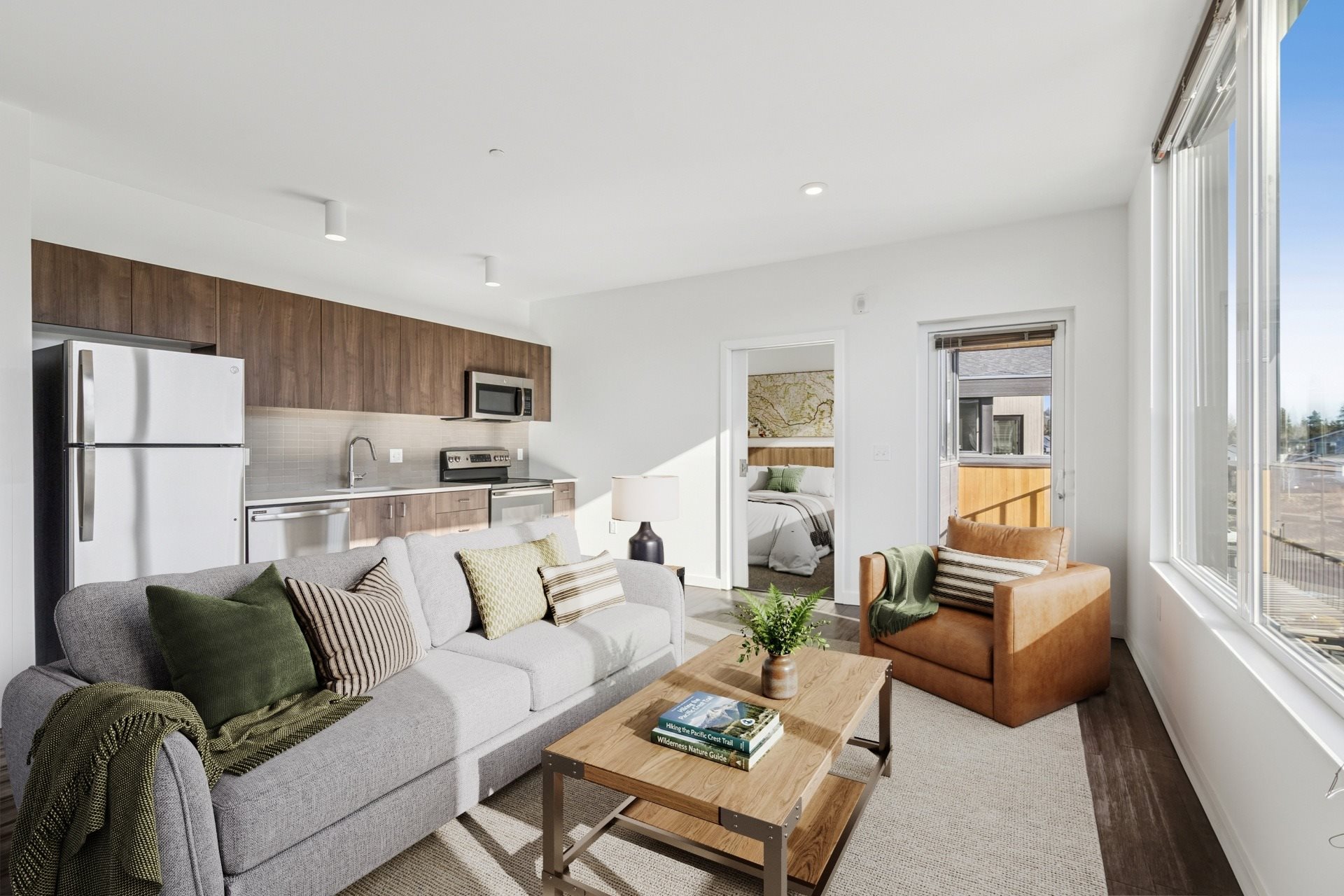 A modern living room with a grey couch, a wooden coffee table, and a large window.